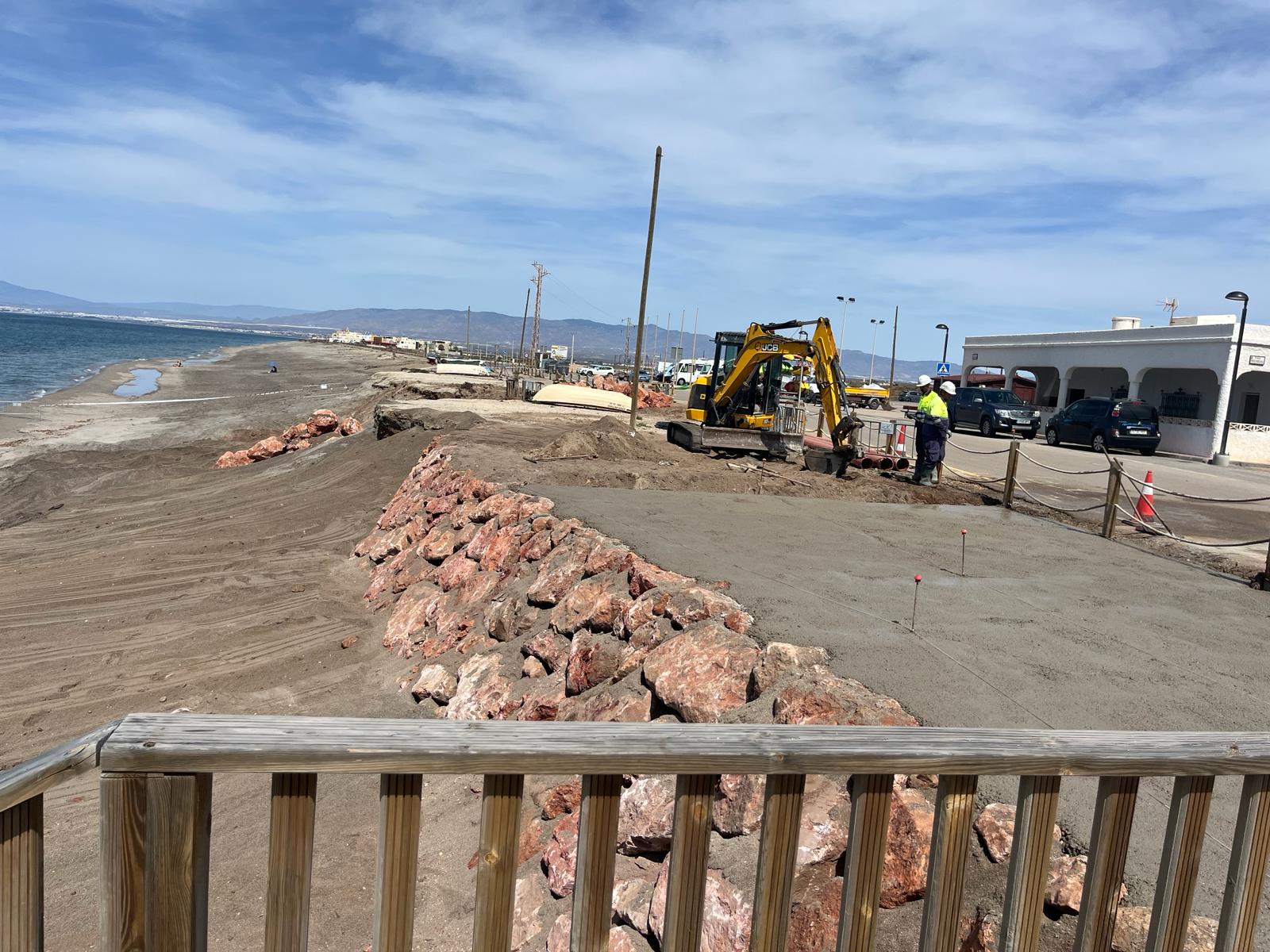 Mini excavadora JCB trabajando en el acondicionamiento del vial junto a la escollera
