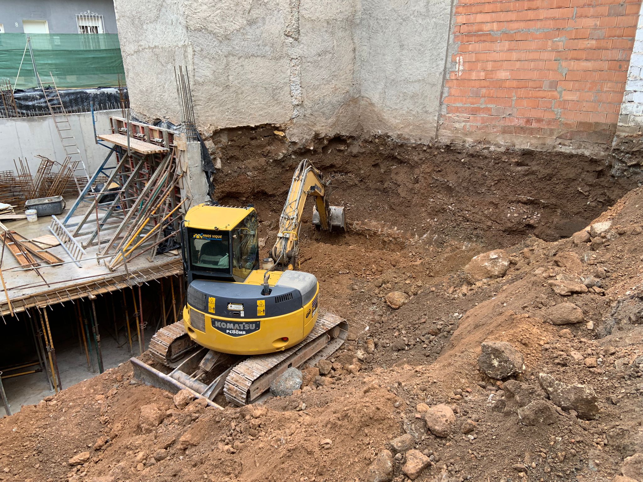 Excavadora Komatsu PC88MR realizando trabajos de excavación por bataches en zona urbana