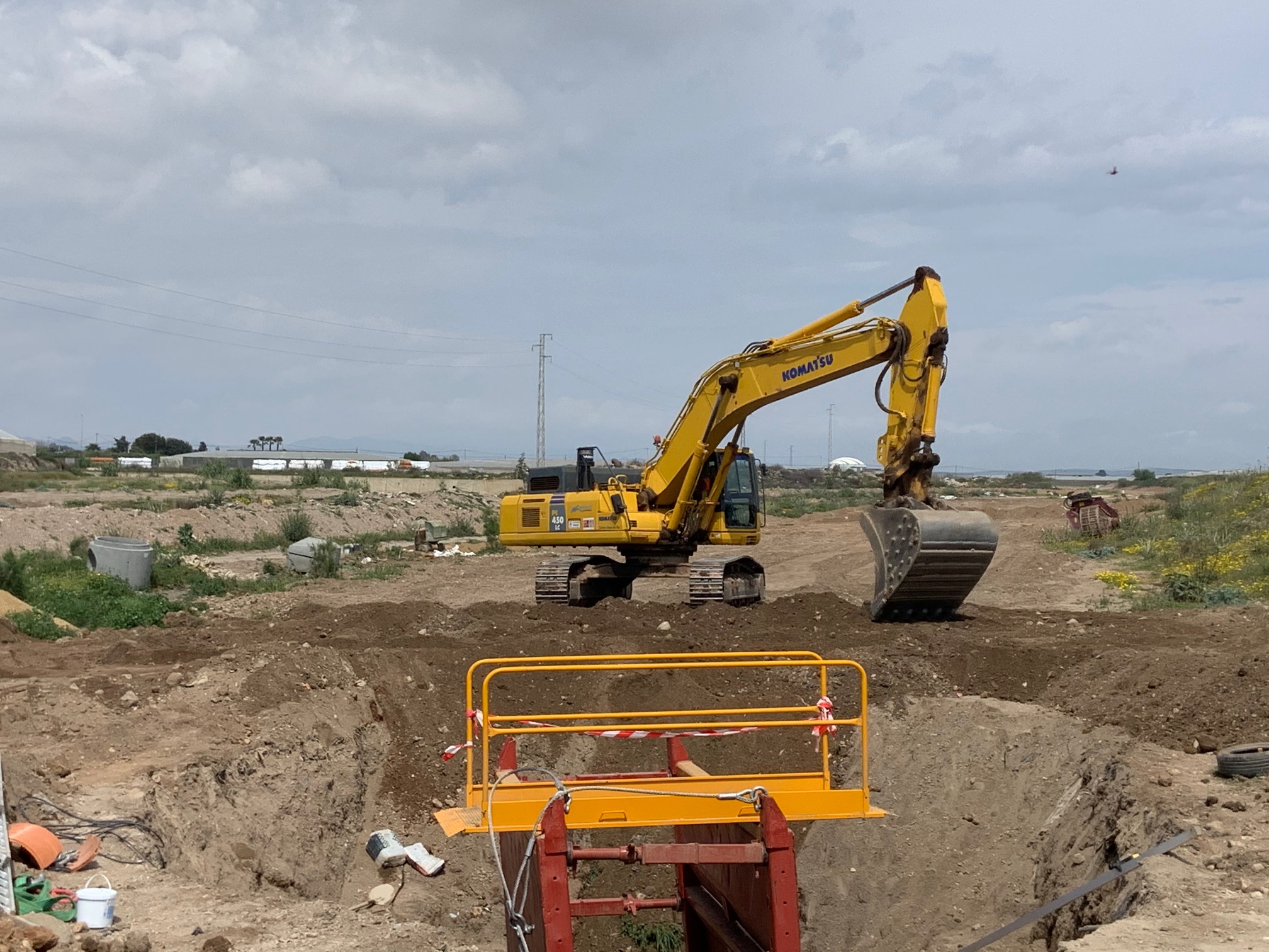 Vista de la excavadora Komatsu trabajando en la zanja con sistema de entibación