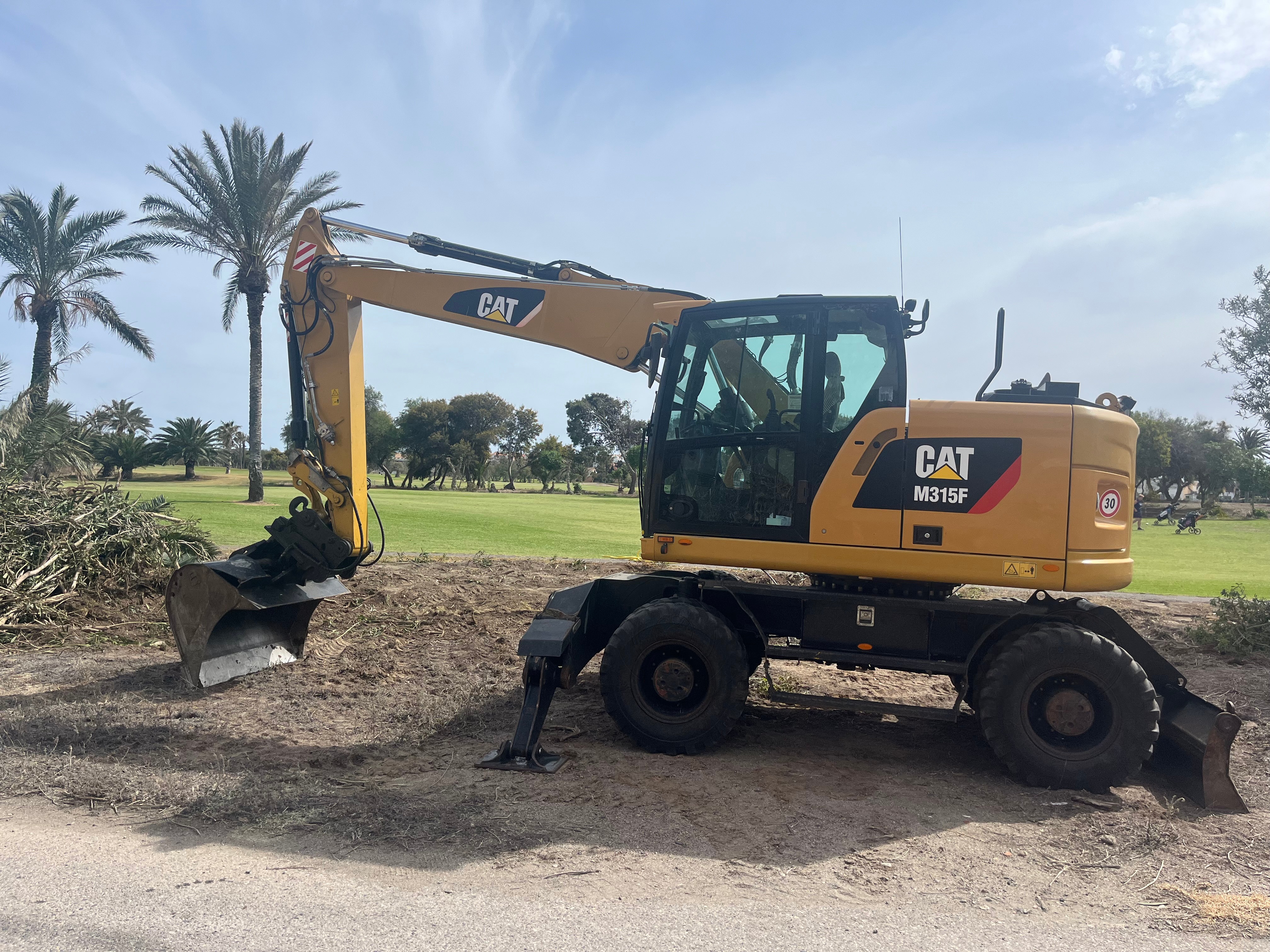 Excavadora CAT M315F realizando trabajos de mantenimiento en el campo de golf de Almerimar