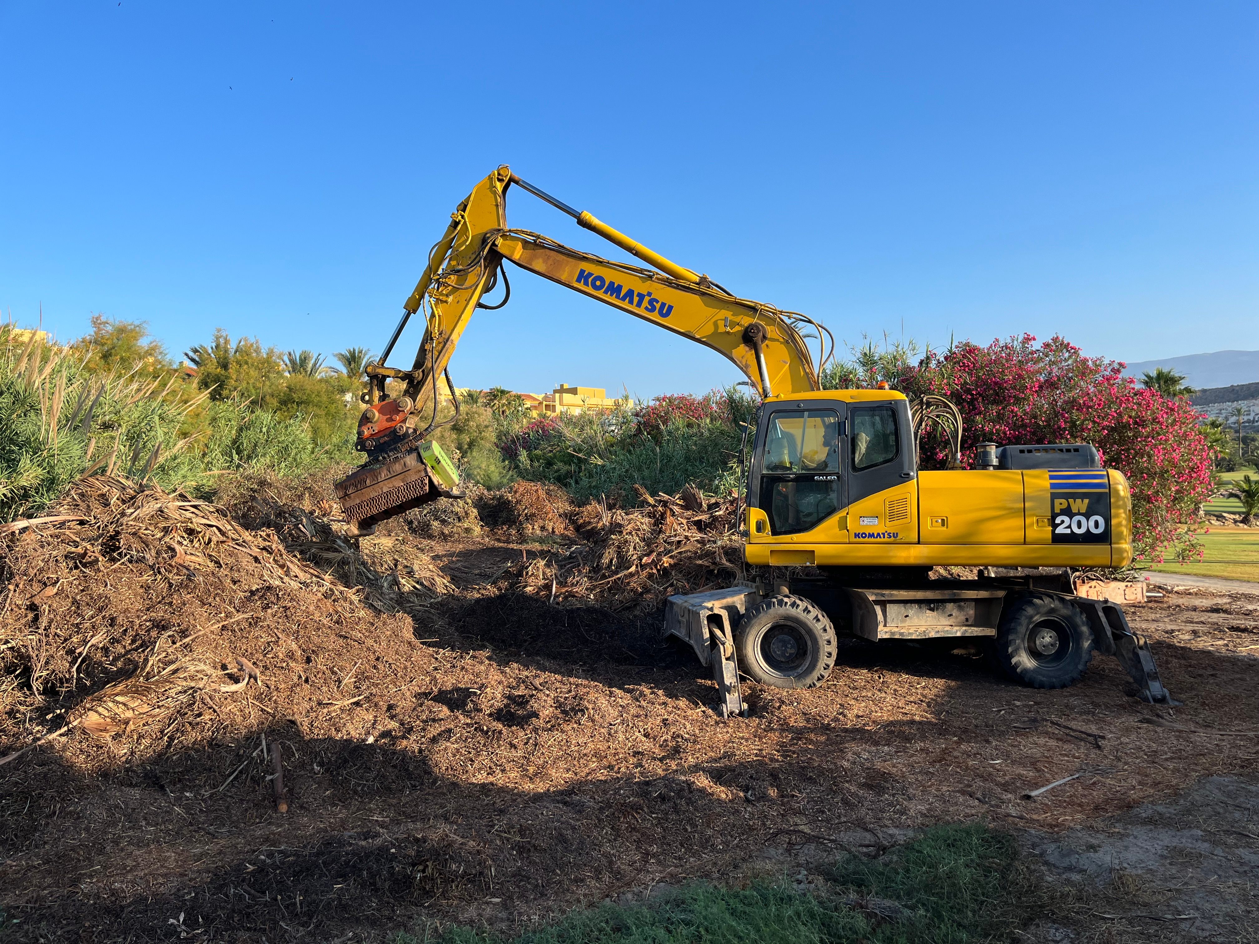Excavadora Komatsu 200 realizando trabajos de desbroce en el campo de golf